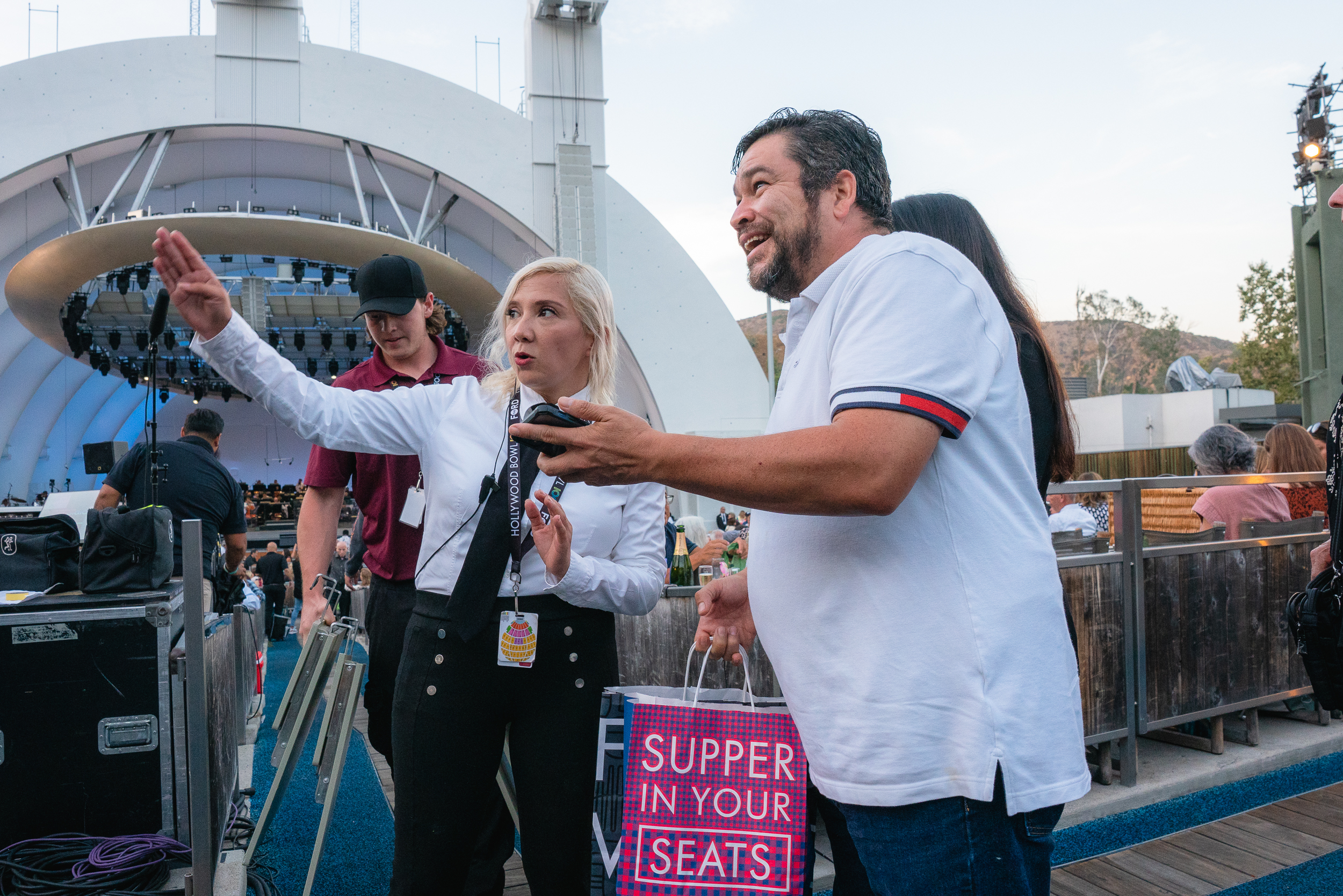Hollywood Bowl usher helping a patron find their seat.